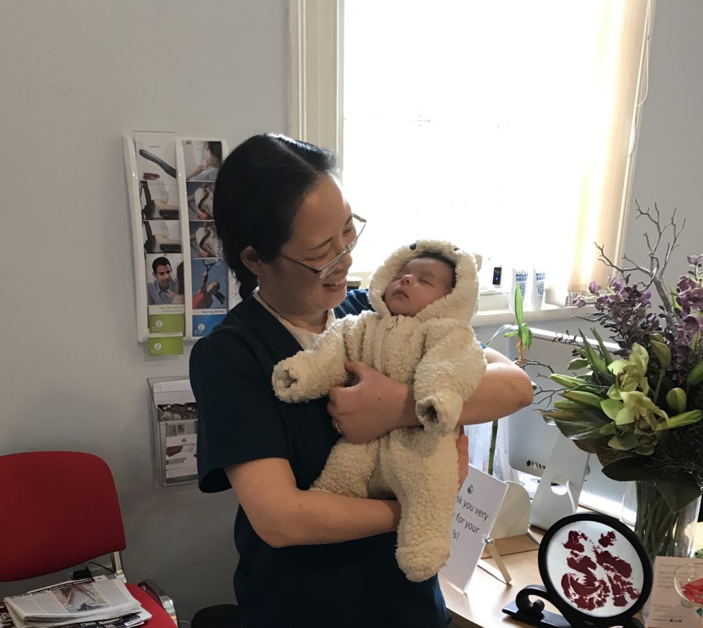 Simin with a baby, the Milton Keynes Chinese Medicine and Fertility Acupuncture cure Center